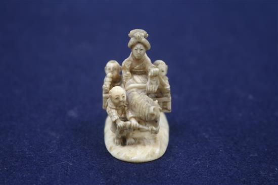 A Japanese carved ivory group of a family travelling with a donkey, height 43mm.